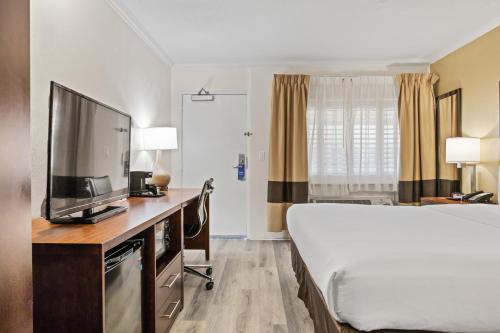 a hotel room with a bed and a flat screen tv at Comfort Inn Santa Cruz North in Santa Cruz