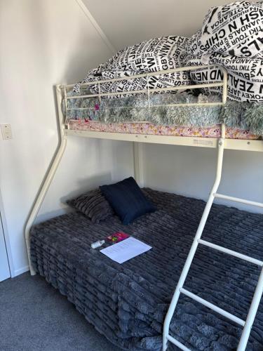 a bunk bed with a paper on the bottom bunk at Kiwi Hosts in Auckland