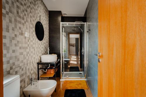 a bathroom with a sink and a toilet and a shower at Trilogia in Lousã