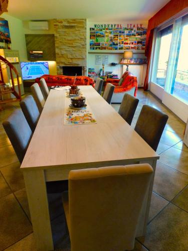 a dining room with a wooden table and chairs at LUKAS HOME CON IL CUORE Appartamento 3 camere al piano terra e appartamento 1 camera in taverna in Merone