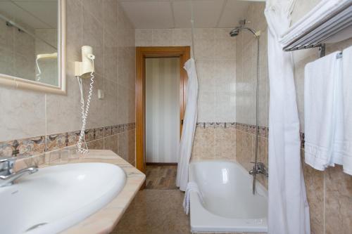 a bathroom with two sinks and a tub and a shower at My Rooms City Hotel Monte Blanco in Neaño