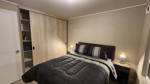 a bedroom with a bed and two lamps and a closet at Moderno, nuevo, excelente ubicación, 1D1B, parking in Los Ángeles