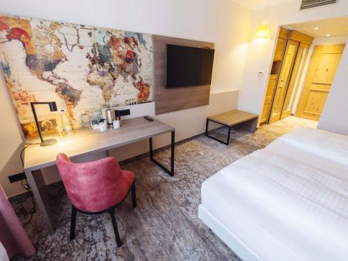 a hotel room with a desk and a map on the wall at Atomis Hotel Munich Airport by Mercure in Oberding