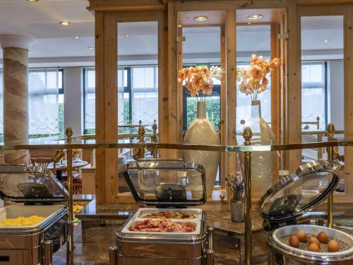 a restaurant with a buffet with food on a table at Atomis Hotel Munich Airport by Mercure in Oberding