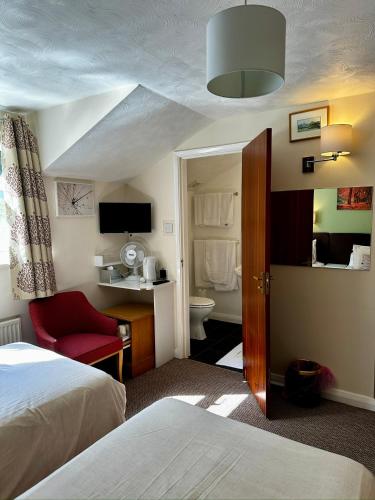 a hotel room with a bed and a bathroom at The Kings Head Inn in Gloucester