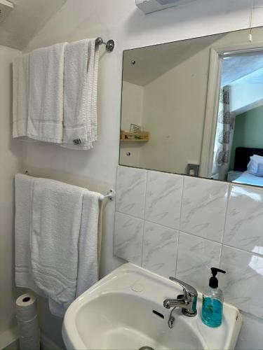 a bathroom with a sink and a mirror and towels at The Kings Head Inn in Gloucester