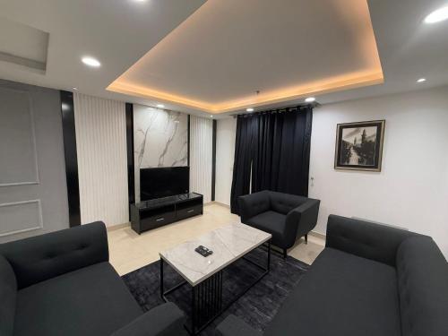 ein Wohnzimmer mit zwei Sofas und einem Flachbildfernseher in der Unterkunft Executive Apartments at Goldcrest Mall DHA phase 4 by Nirvana Nests in Lahore