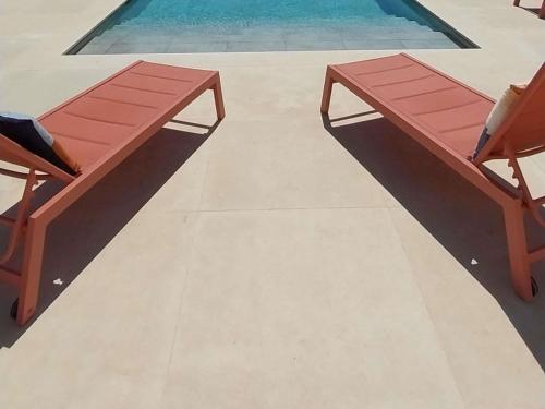 a wooden bench sitting next to a swimming pool at ibis Styles Cabriès Aix-en-Provence TGV in Cabriès
