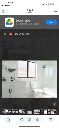 a bathroom with a white sink and a toilet at Kiwi Hosts in Auckland