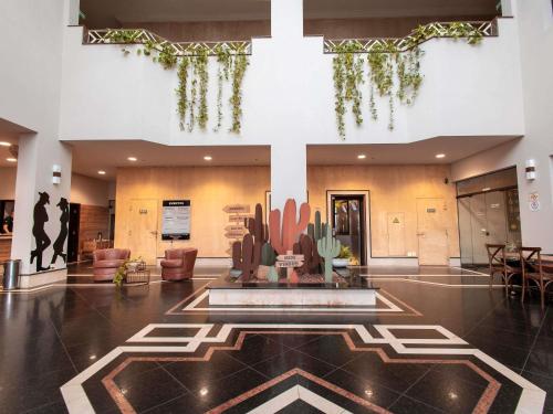 a lobby with a fountain in the middle of a building at ibis Styles Presidente Prudente Portal D'Oeste in Presidente Prudente