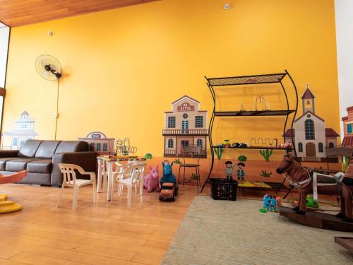 a living room with a couch and a table and chairs at ibis Styles Presidente Prudente Portal D'Oeste in Presidente Prudente