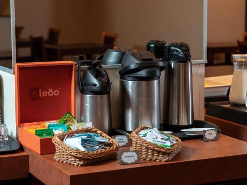 a counter with two baskets and two kettles at ibis Styles Presidente Prudente Portal D'Oeste in Presidente Prudente