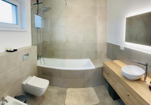 Villa Lozorno في لوزورنو: حمام مع حوض استحمام ومرحاض ومغسلة