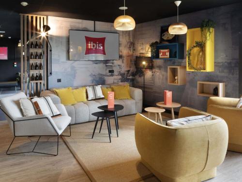 a living room with couches and chairs and tables at ibis Douai Dechy in Dechy
