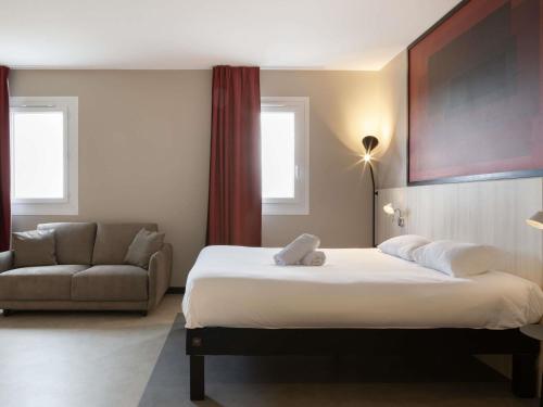 a hotel room with a bed and a couch at ibis Douai Dechy in Dechy