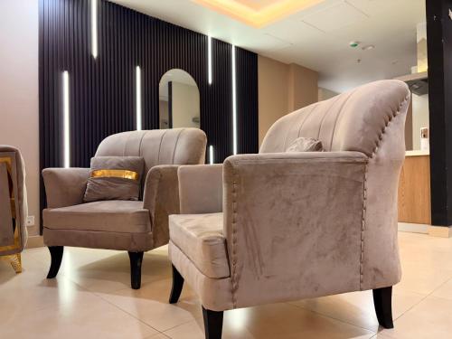 ein Salon mit zwei Stühlen und einem Spiegel in der Unterkunft Executive Apartments at Goldcrest Mall DHA phase 4 by Nirvana Nests in Lahore