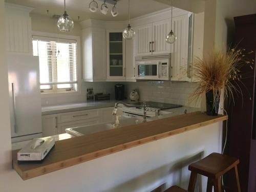 a kitchen with white cabinets and a wooden counter top at Le Belvedère Mont-Tremblant in Mont-Tremblant
