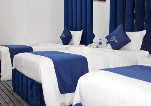 a group of three beds with blue and white sheets at The Beach Villa in Mount Lavinia