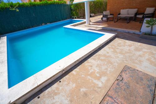 einen Pool im Hinterhof mit blauem Pool in der Unterkunft Urbasur Villa Islantilla Golf in Isla Cristina