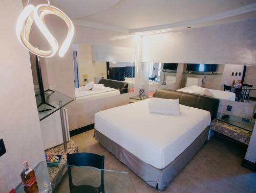 a bedroom with a large white bed in a room at Trópicos Motel in Natal