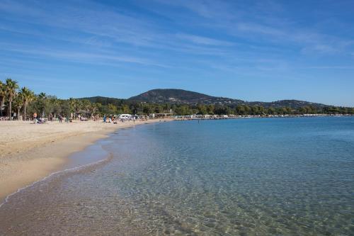 a beach with a group of people and the water at SOWELL RESIDENCES Les Perles du Golfe de Saint-Tropez in Grimaud