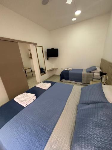a hotel room with two beds and a flat screen tv at Multiespacio Center in San Fernando del Valle de Catamarca