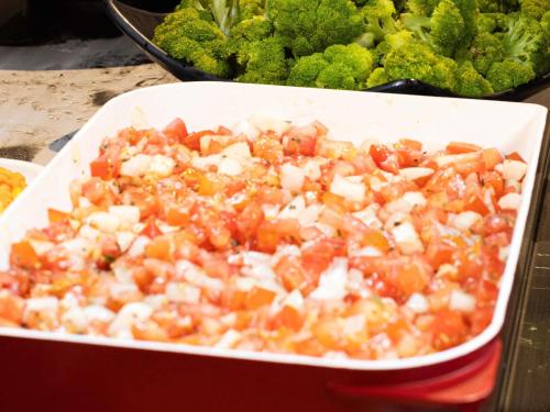 a white dish of food with tomatoes and onions at ibis Barra do Garcas in Barra do Garças