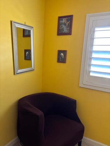 a yellow room with a mirror and a couch at Yellow Cactus Oasis in White Water