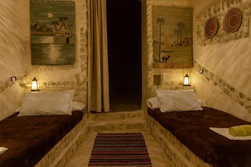 two beds in a room with two lamps at Soléi Salt Caves in Siwa