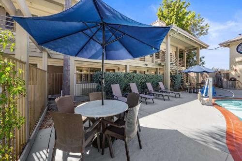 a blue umbrella sitting on a table next to a pool at Comfort Inn Santa Cruz North in Santa Cruz
