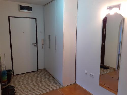 a hallway with two white doors and a mirror at Apartman centar lux in Tuzla