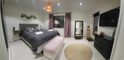 a bedroom with a bed and a chair and a television at VillaApaja in Rovaniemi