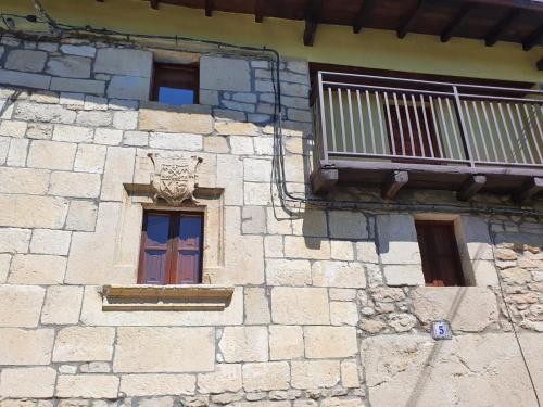 a stone building with a window and a balcony at Casa Rural Baratza 