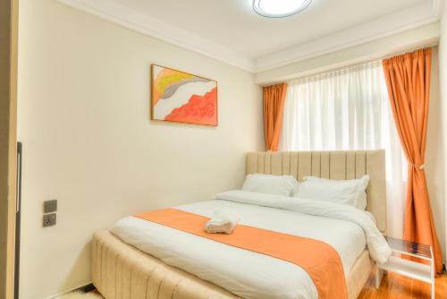 Un dormitorio con una cama grande con una manta naranja. en Kindaruma A401, en Nairobi