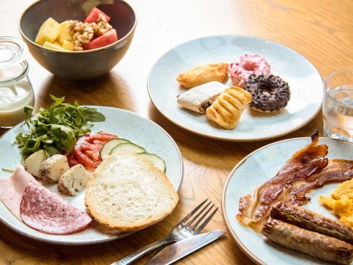 three plates of food on a wooden table at Number 11 St Julian's Malta - Handwritten Collection in St Julian's