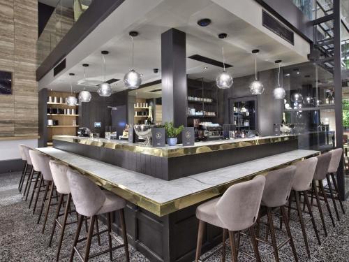 a bar with a long counter with stools at Number 11 St Julian's Malta - Handwritten Collection in St Julian's