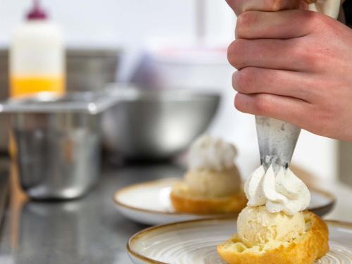a person is eating ice cream on a pastry at greet Hotel Massieux Lyon Nord in Massieux