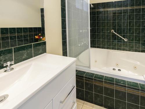 a bathroom with a white tub and a sink and a bath tub at Breakfree Port Pirie in Port Pirie