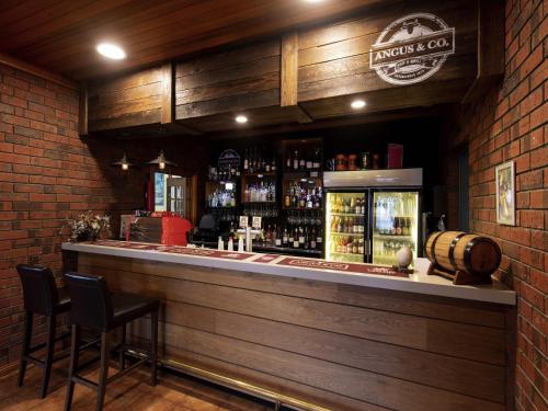 a bar with two chairs and a counter with alcohol at Breakfree Port Pirie in Port Pirie
