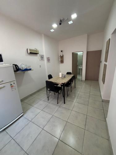 a kitchen with a table and chairs and a refrigerator at Multiespacio Center in San Fernando del Valle de Catamarca