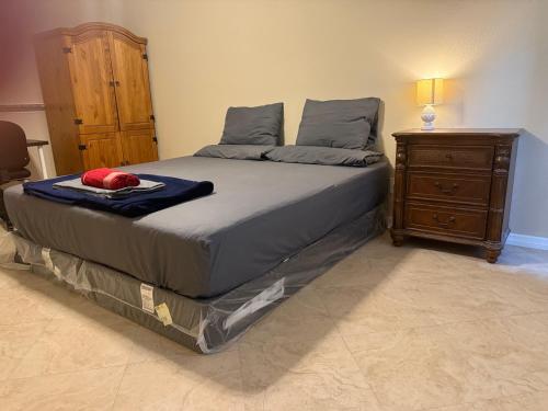 a bedroom with a bed and a wooden dresser at Tutul House in Tampa