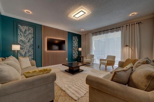 a living room with two couches and a living room with a television at NEW, Disney,10mi, Themed Rooms, PvtPool, Movie, Game Room in Kissimmee