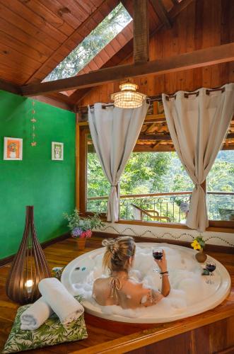 a woman in a bath tub in a room at Pousada do Rio Maua in Visconde De Maua