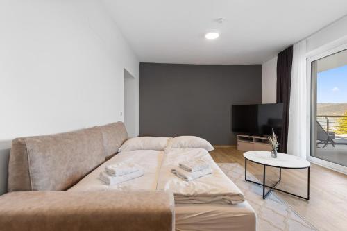 a living room with a couch and a tv at Maria Blick - Design Apartments am Wörthersee in Maria Wörth