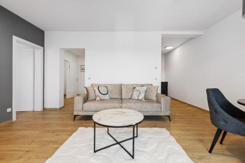 a living room with a couch and a table at Maria Blick - Design Apartments am Wörthersee in Maria Wörth