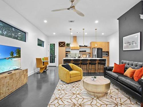 a living room with a couch and a table and a kitchen at South Lamar Luxe Creekside Retreat with POOL in Austin