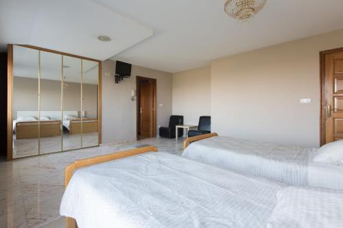 a hotel room with two beds and a mirror at My Rooms City Hotel Monte Blanco in Neaño