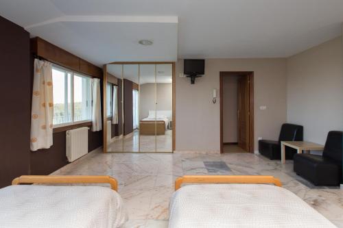 a bedroom with two beds and a mirror at My Rooms City Hotel Monte Blanco in Neaño