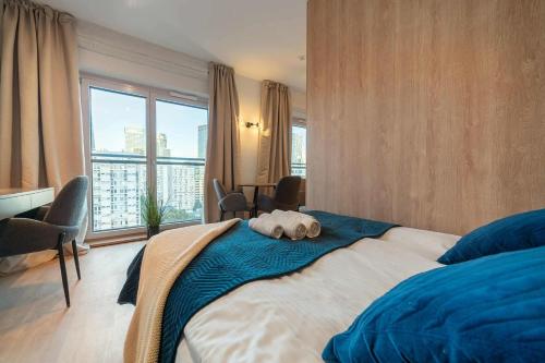a bedroom with a bed with a towel on it at Luxury Apartment Mennica Residence strefa wellness and sport by P&M in Warsaw