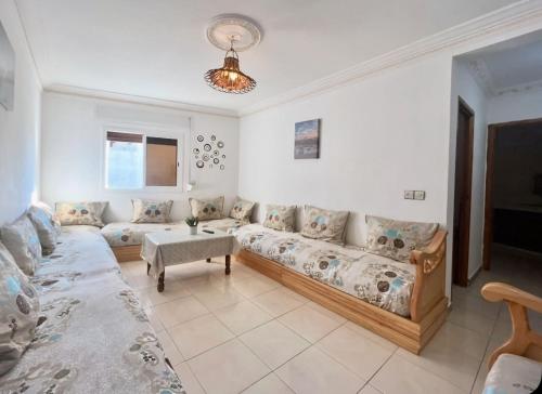 una sala de estar con un sofá y una mesa en Mamoun allawii, en Asilah